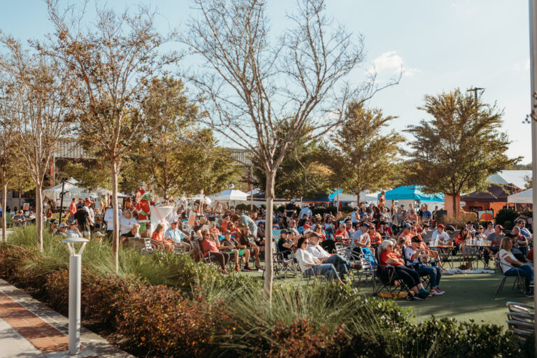 Crowd gathered on lawn chairs at an outdoor community festival at The Mill on Etowah green space