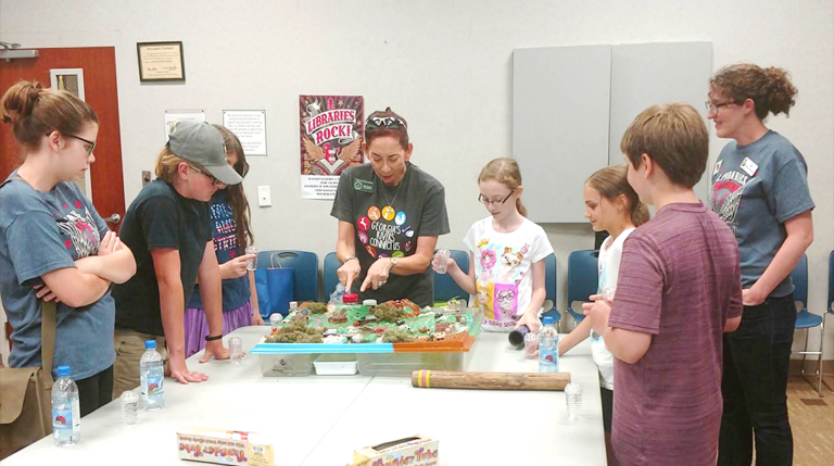 UERA education volunteer demonstrating a watershed to local kids at the Dawson Public Library