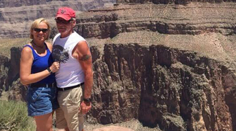 A photo of Mary Sorensen and her husband standing by the Grand Canyon.